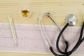 Electrocardiogram with stethoscope on wooden table