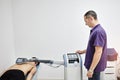 Electromagnetic therapy of the back. Physiotherapist doctor uses medical equipment for highly effective pain treatment and