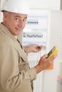 Electromechanic in electrical next to fuseboard Royalty Free Stock Photo