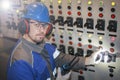 electromechanic in electrical safety gloves holds power cable, cabling connection of high voltage power electric line in