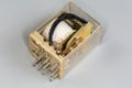 Electromechanical coil relay in transparent dust cover on gray background Royalty Free Stock Photo