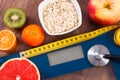 Electronic bathroom scale, centimeter and stethoscope, healthy food, slimming and healthy lifestyles concept Royalty Free Stock Photo