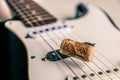 Electronic black and white guitar cluse up with wine cork on guitar strings Royalty Free Stock Photo