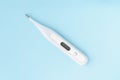 Electronic body thermometer on blue background. Modern termometer with digital display, diagnostic instrument