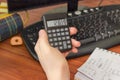 Electronic calculator in the hand of schoolboy over the desktop Royalty Free Stock Photo