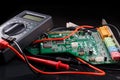 Electronic circuit board and digital multimeter Royalty Free Stock Photo