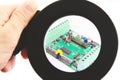 Electronic circuit with figure seen through magnifying glass. Royalty Free Stock Photo