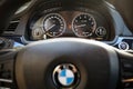 Electronic dashboard of modern luxury BMW 750Li XDrive car with wheel out of focus with the BMW logo