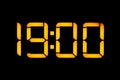 Electronic digital clock with orange numbers on a black background shows the time Nineteen zero zero in the evening. Isolate,