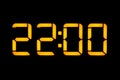 Electronic digital clock with orange numbers on a black background shows the time Twenty-two zero hours of the evening. Isolate,