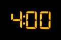 Electronic digital clock with yellow numbers on a black background shows the time four zero hours of the night. Isolate, close-up