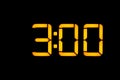 Electronic digital clock with yellow numbers on a black background shows the time three zero hours of the night. Isolate, close-up