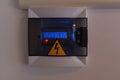 Electronic electricity meter and yellow warning sign of electrical danger