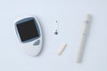 Electronic glucometer, lancet and test strip for determining blood sugar levels on white background