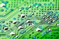 Electronic green printed circuit board with soldered copper contacts, holes, close-up, selective focus