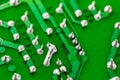 Electronic green printed circuit board with soldered copper tin contacts, close-up, selective focus