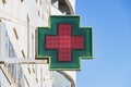 Electronic green and red cross outside a pharmacy