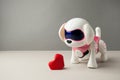 Electronic interactive toy dog puppy with red paper origami heart on a gray background, high technology concept, pet of the future