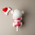 Electronic interactive toy dog puppy with red paper origami heart on a gray background, high technology concept, pet of the future