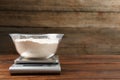 Electronic kitchen scale with bowl of flour on wooden table, closeup. Space for text Royalty Free Stock Photo