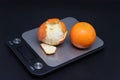 Electronic kitchen scale with two tangerines, calorie counting. Royalty Free Stock Photo