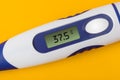 Electronic medical thermometer 37.5 degrees on yellow background Royalty Free Stock Photo