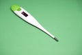 Electronic medical thermometer on a green background Royalty Free Stock Photo