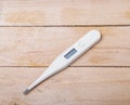 Electronic medical thermometer on wooden background