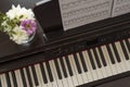 Electronic piano with notes and flowers in a vase