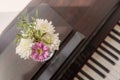 Electronic piano with notes and flowers in a vase