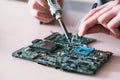 Electronic repair engineer soldering motherboard