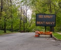 Electronic road sign on a suburban street that says Go Army Beat Navy.