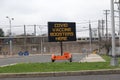 Electronic sign in a parking lot that flashes, COVID Boosters Here