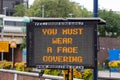 An electronic signboard outside a train station stating that you must wear a face mask during the coronavirus pandemic