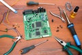 Electronic system board with microcircuits and electronic components. Necessary tools for repair.