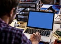 Electronic technician man at repair shop with blank screen laptop on the table