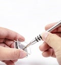 Electronic technician removing metal nut with a precision screwdriver