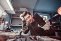 Electronic technician showing a smartphone with a broken body in a repair shop