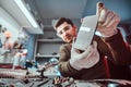 Electronic technician showing a smartphone with a broken body in a repair shop