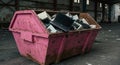 Electronic Waste Disposal Bin A pink dumpster overflowing with discarded electronic devices including laptops and computer Royalty Free Stock Photo