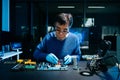 Electronics engineer repairing circuit board in laboratory. Technology, hardware repair, engineering, innovation, diagnostics, and Royalty Free Stock Photo