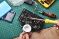 Electronics repair service, Technician fixing electronic circuit board with soldering iron and tin