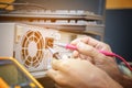 Electronics technician hands use digital multimeter pen checking