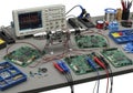 Electronics workbench with circuit boards, oscilloscope, soldering iron, and various tools for electronic repair and testing Royalty Free Stock Photo