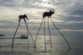 Elefanten Skulpturen auf langen Stelzen im Meer mit Fischerbooten und Motorboot im Hintergrund bei Sonnenuntergang in Phu Quoc,