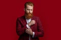 Elegance of bearded gentleman in formal suit. Formalwear. Tux man in formalwear isolated on red. Redhead man in