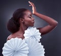 Elegance is beauty that never fades. Studio shot of a beautiful young woman posing with origami fans against a black