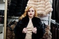 Elegance blonde girl in fur coat store