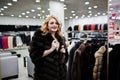Elegance blonde girl in fur coat store