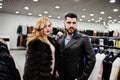 Elegance blonde girl in fur coat and stylish turkish man at the store of fur coats and leather jackets Royalty Free Stock Photo